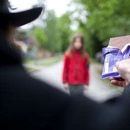 Ein Mann versucht ein Kind mit Schokolade zu locken (Themenbild).