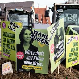 Plakate mit der Aufschrift "Wahl Lügen" stecken während einer Demonstration vor der Stadthalle in Biberach zum politischen Aschermittwoch der Grünen in einem Misthaufen.