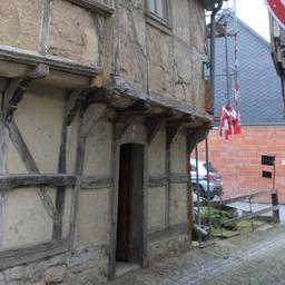 Ein altes Fachwerkhaus, rechts ein rundes Schild.