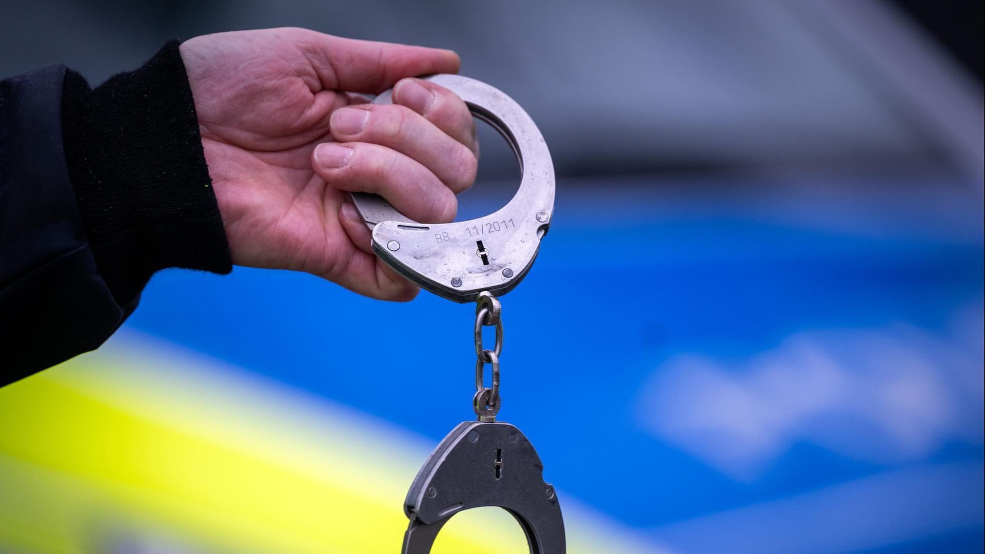 Polizist hält Handschellen  | Soeren Stache/dpa