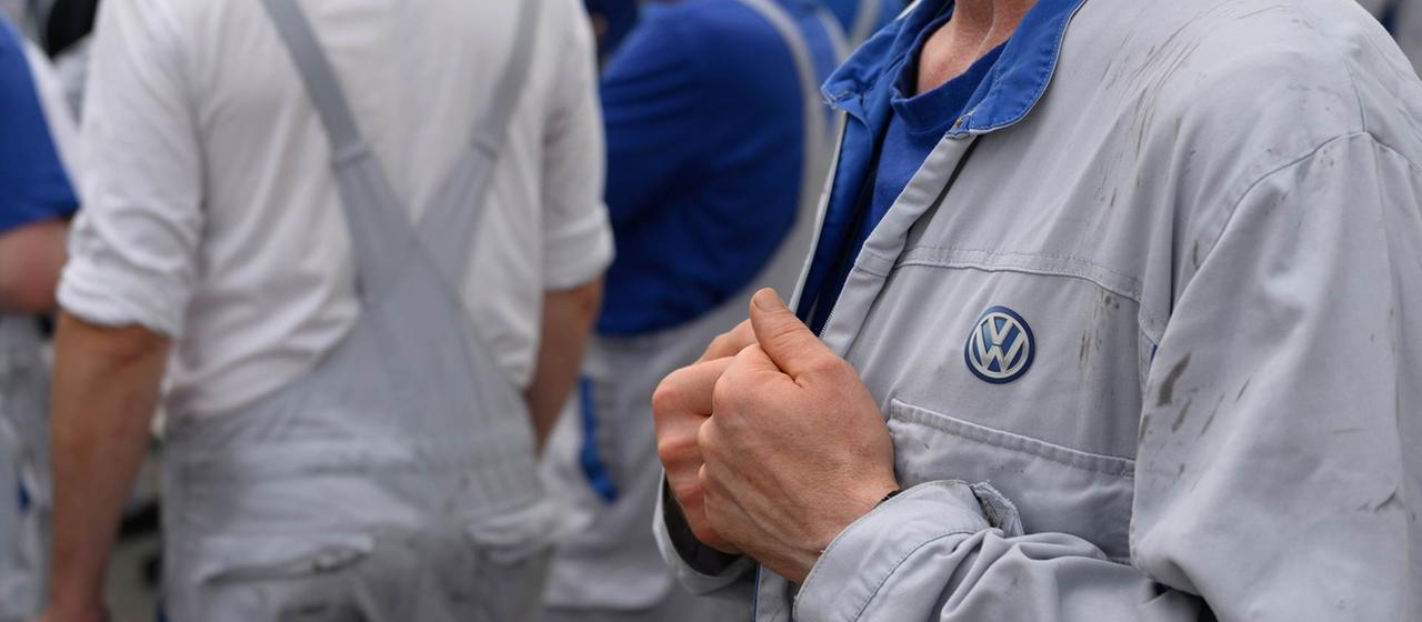 Beschäftigte der Volkswagen Sachsen GmbH stehen vor dem Werkstor.