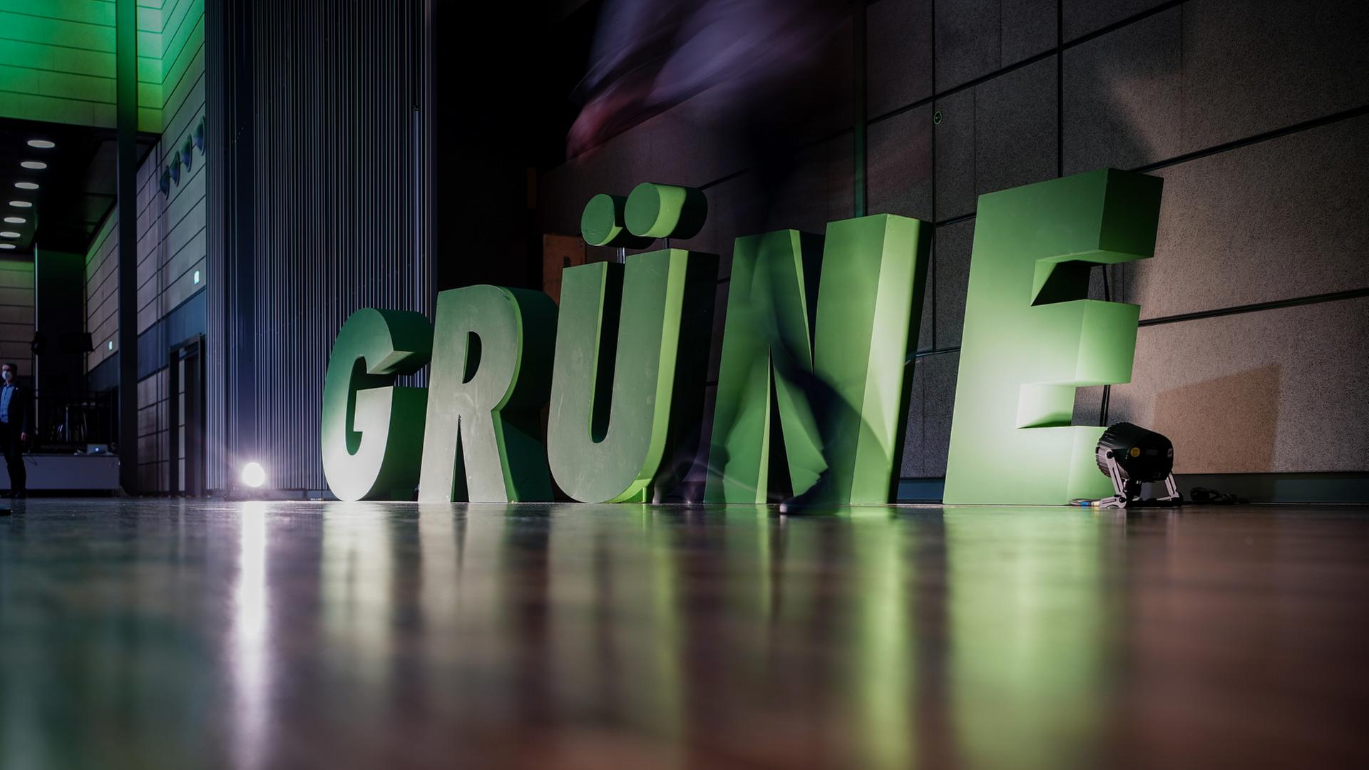 Ein Delegierter geht beim Bundesparteitag von Bündnis 90/Die Grünen am Logo seiner Partei vorbei. | dpa