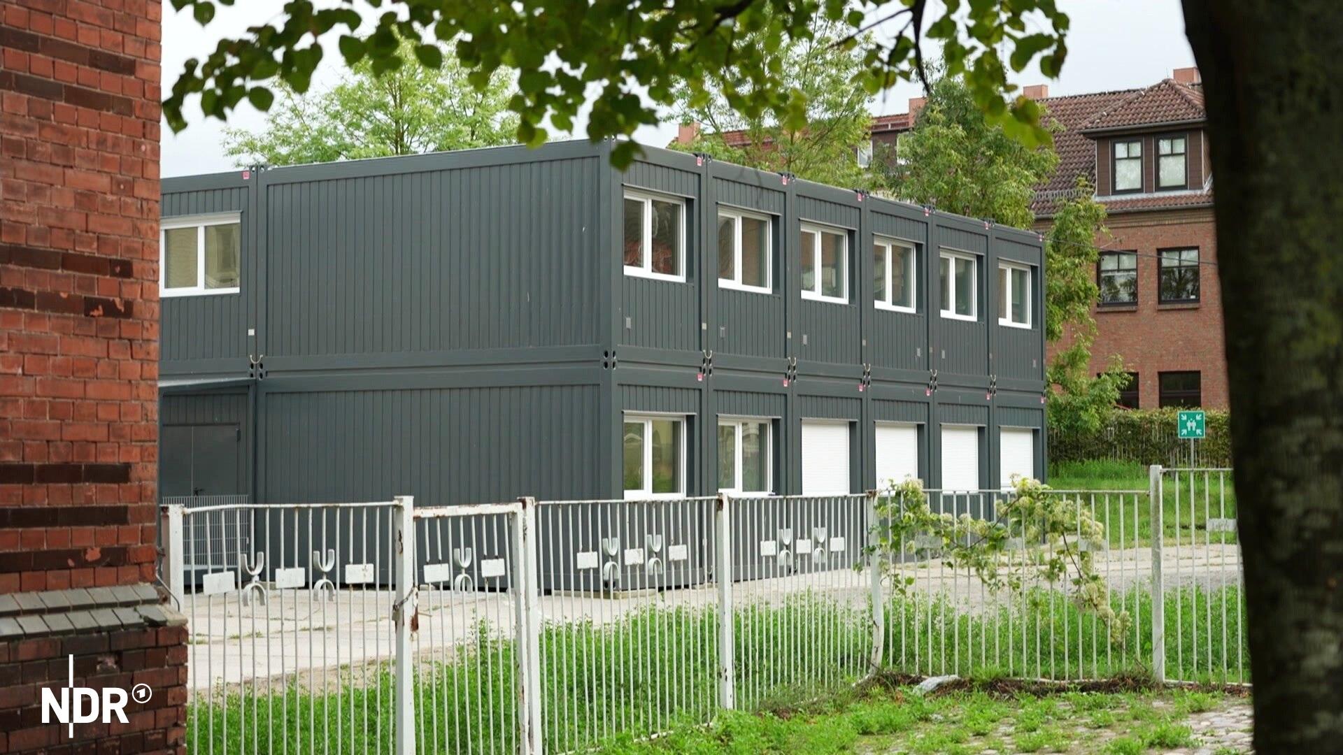 Die Wohncontainer für Flüchtlinge in Malchin stehen bereits. Die Stadt wollte gerichtlich gegen sie vorgehen. | Screenshot Blick durch einen Torbogen aus Backstein auf Wohncontainer für Flüchtlinge in Malchin