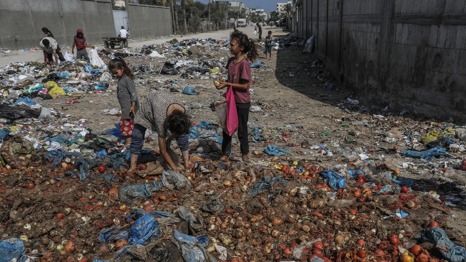 Palästinensische Kinder suchen im Müll nach Lebensmitteln.  | picture alliance/dpa