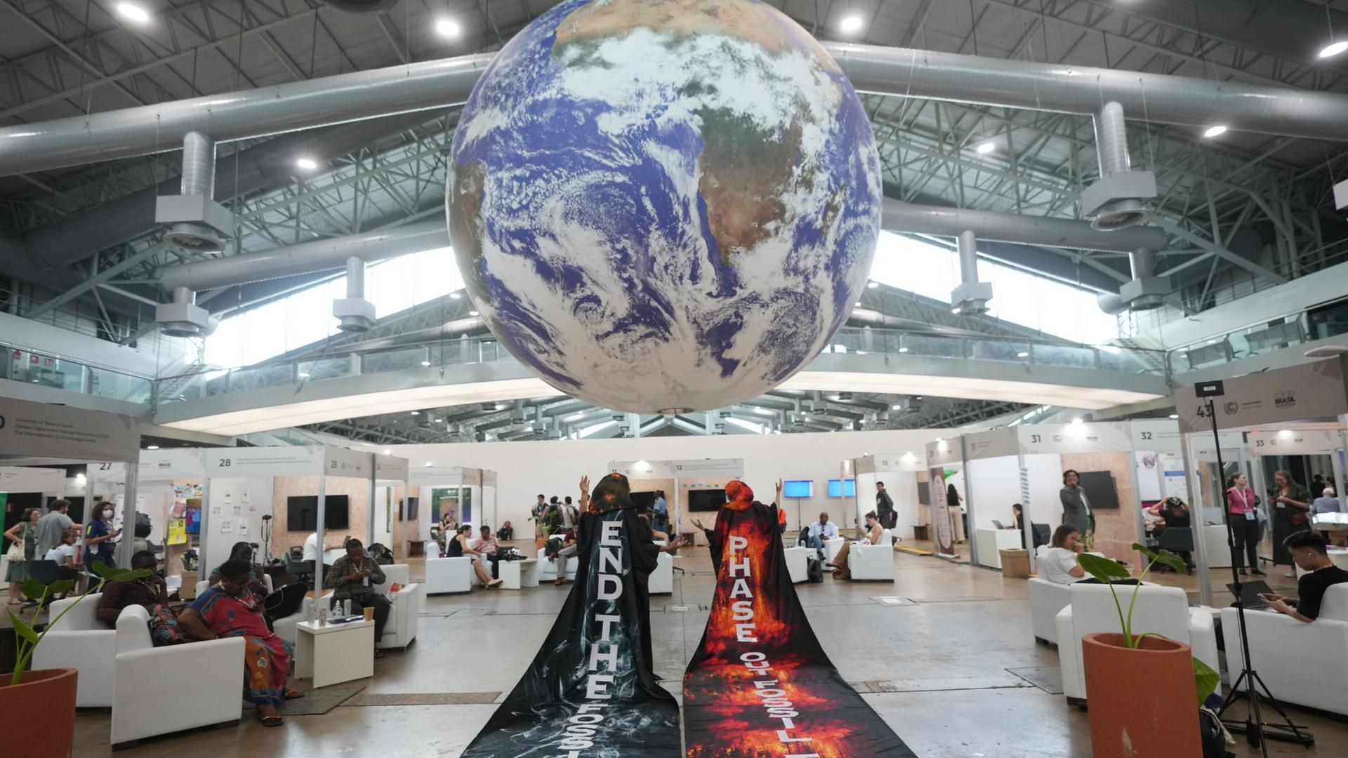 Aktivisten stehen unter einem Erdball, der von der Decke hÃ¤ngt. | AP