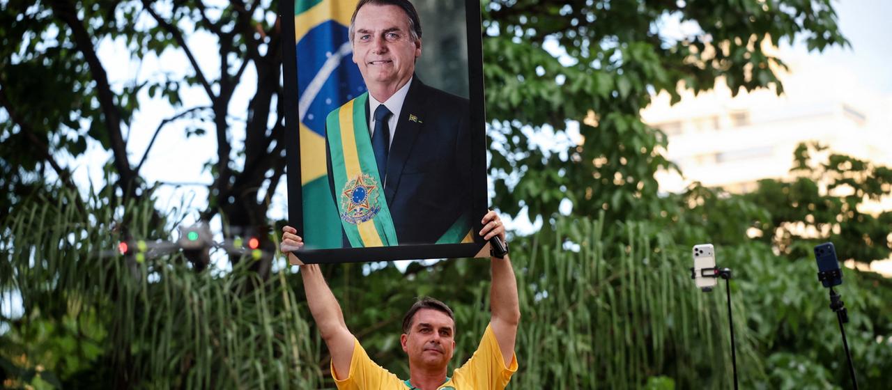 Flávio Bolsonaro hält ein Bild Jair Bolsonaros in die Höhe