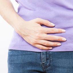 Ein Frau hält sich den Bauch.