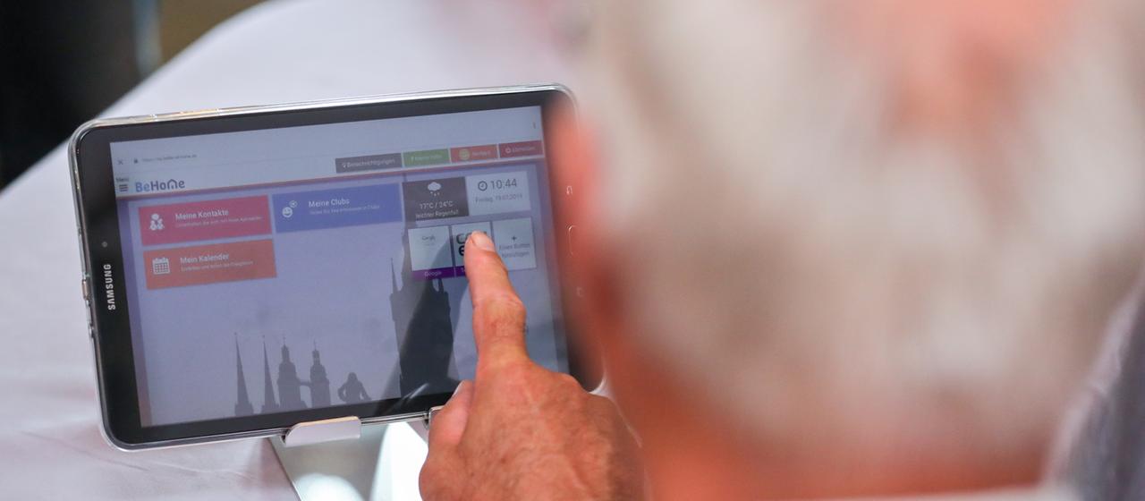 Ein Rentner spricht über einen Videoanruf via Tablet mit seinem Hausarzt.