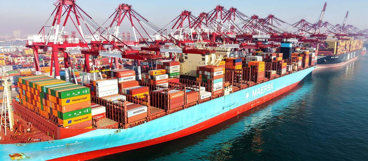 Voll beladene Containerschiffe im Hafen von Qingdao, China.