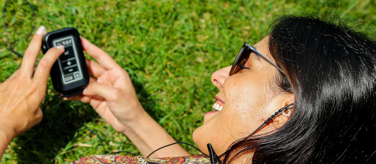 Eine Frau hält einen Vagusnerv-Stimulator in den Händen.