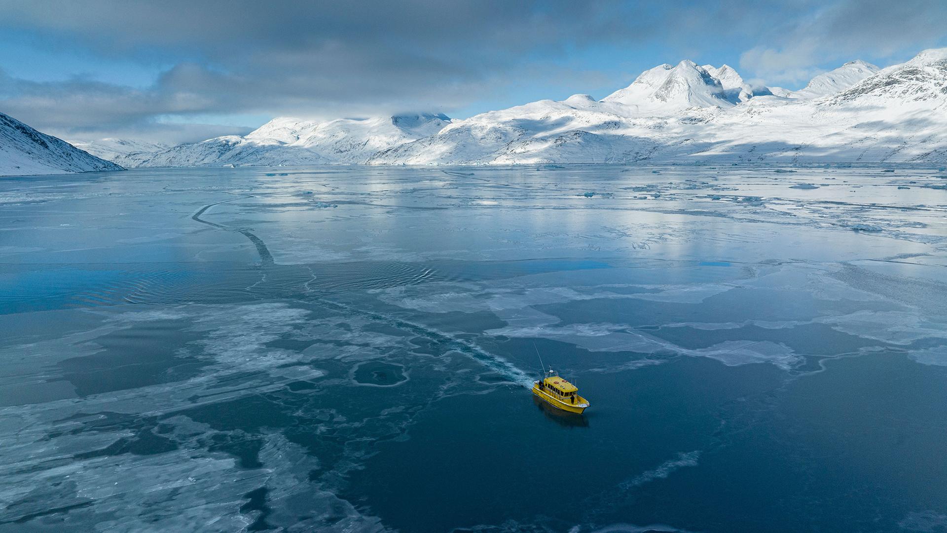 Ein Boot fährt durch einen zugefrorenen Meeresarm außerhalb von Nuuk. | dpa