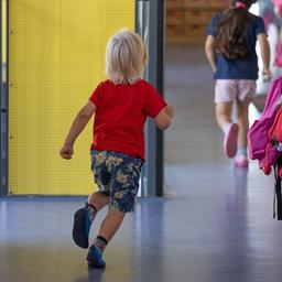 Ein Kind läuft in einer Kita über einen Flur. 