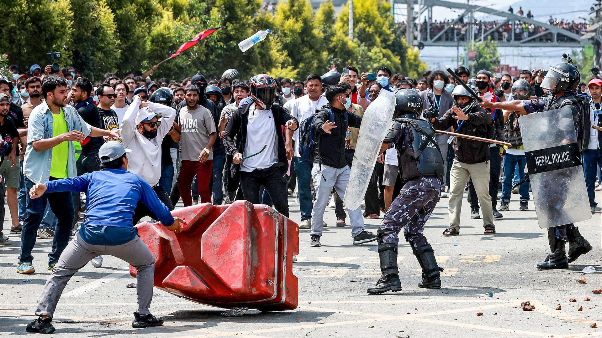 Demonstranten in Kathmandu bewerfen Bereitschaftspolizisten mit Steinen und Stöcken. | AFP