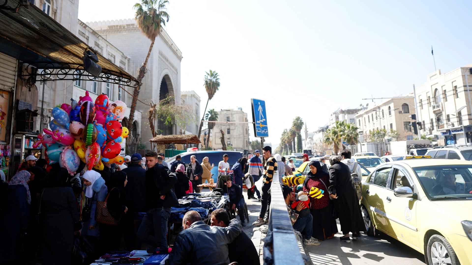 Menschen kaufen auf einem Markt in Damaskus Kleidung. | REUTERS