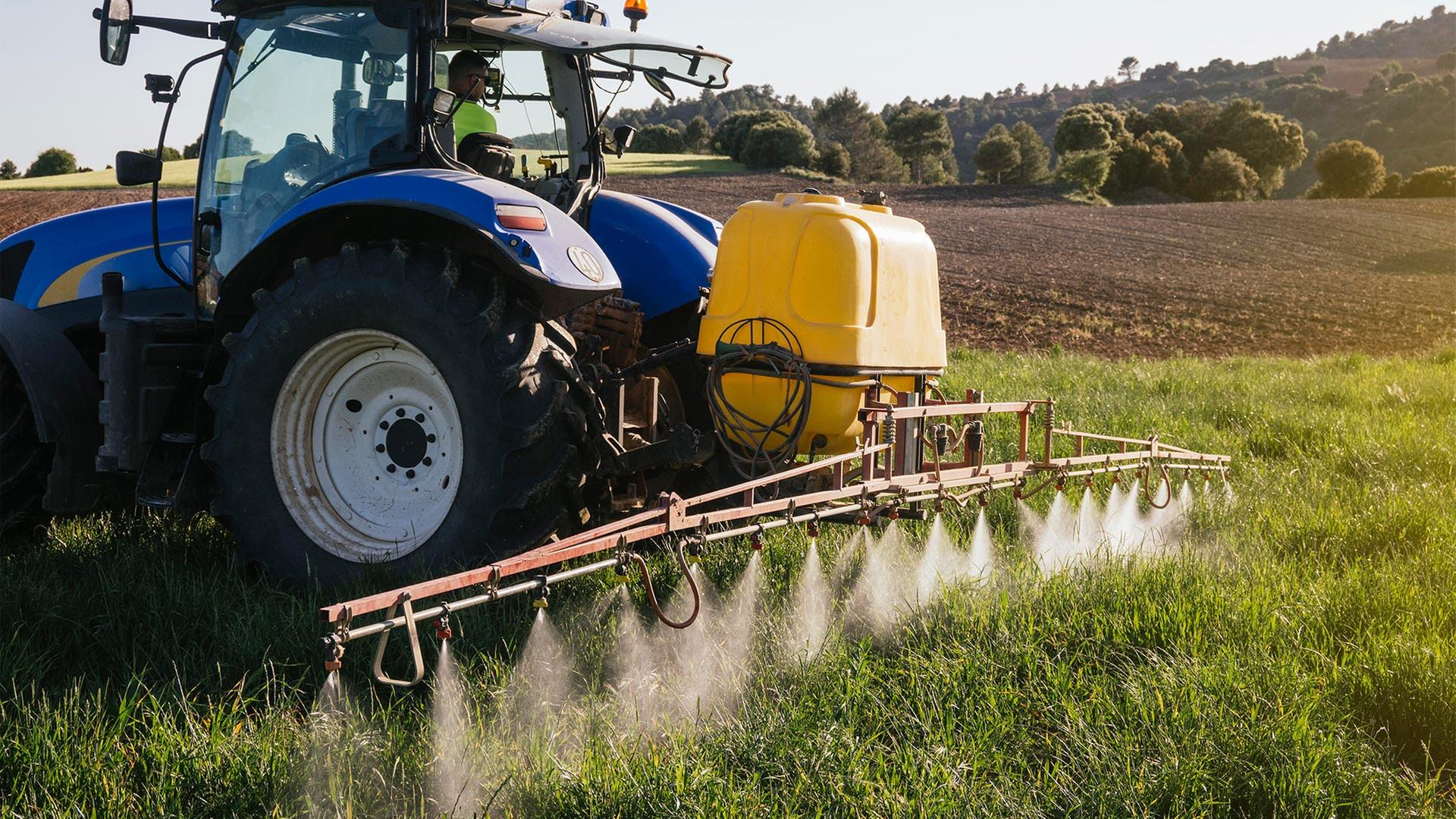 Mit einem Traktor wird Düngemittel auf einem Feld ausgebracht. | picture alliance / Westend61