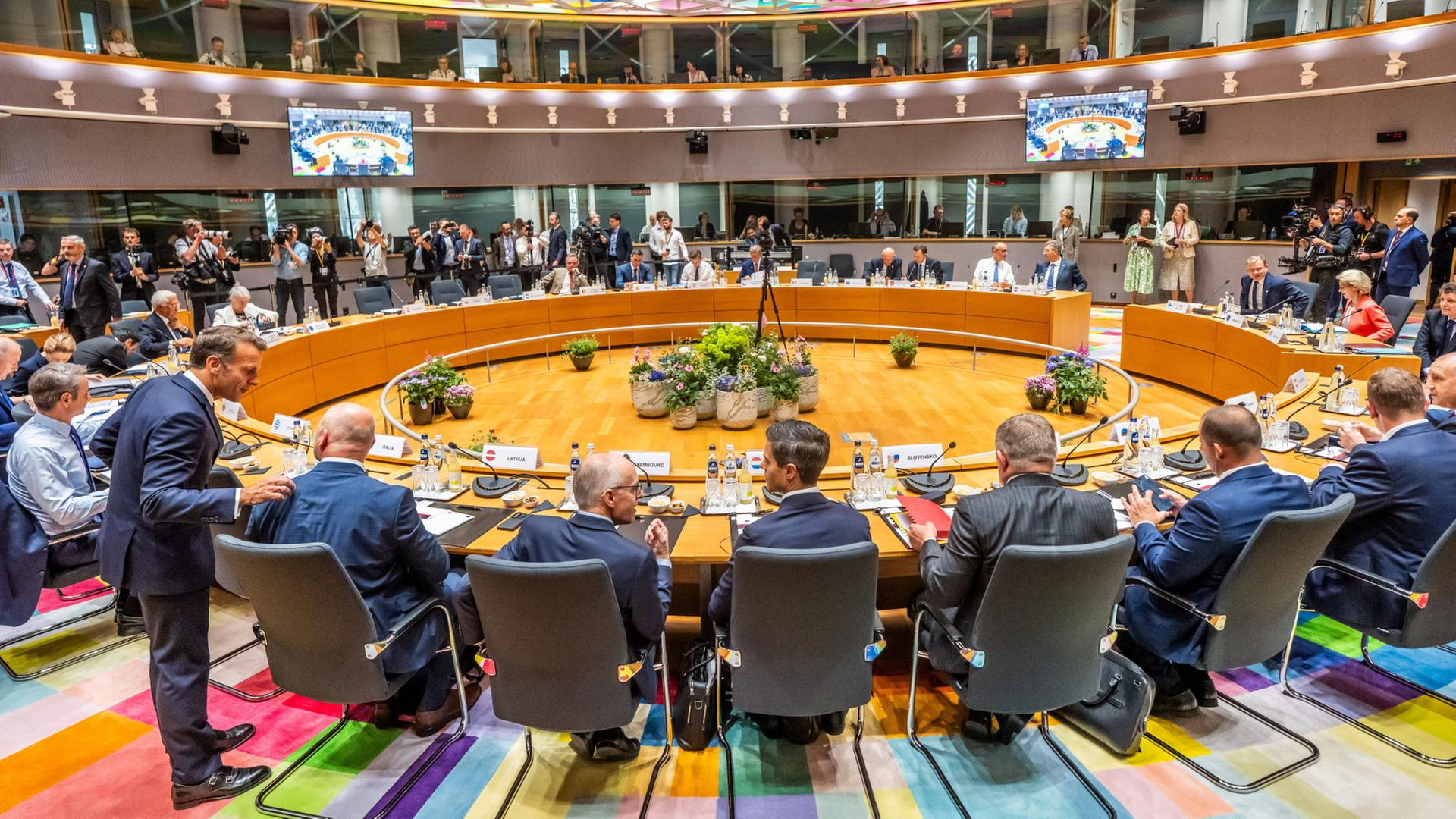 EU-Staats- und Regierungschefs sitzen an einem runden Besprechungstisch. | Michael Kappeler/dpa