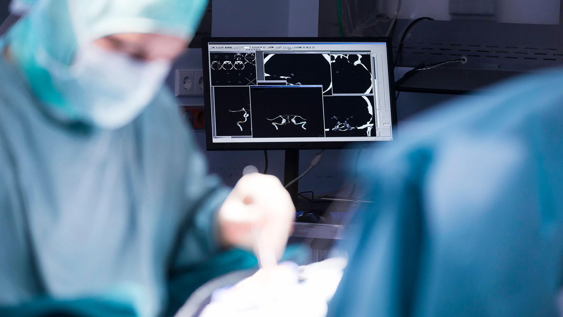 Ein Arzt beugt sich bei einer Operation über einen Patienten (Quelle: dpa/Weis) | dpa/Weis