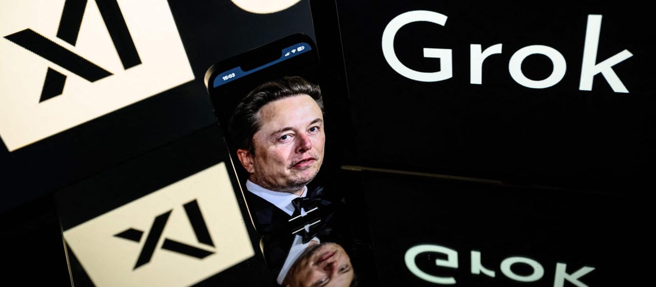 Bildschirme zeigen die Logos von Grok, xAI und Elon Musk. (Archiv)