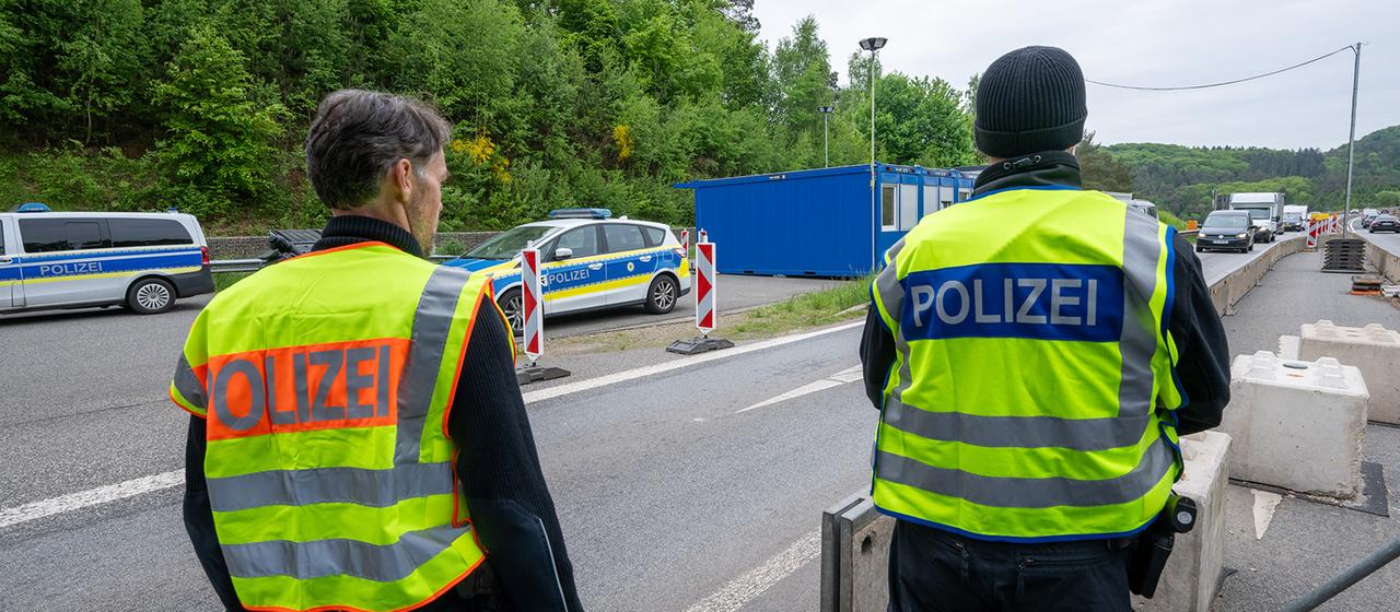 Polizisten beobachten an einer Kontrollstelle auf der A64 Nahe der luxemburgischen Grenze den Verkehr.