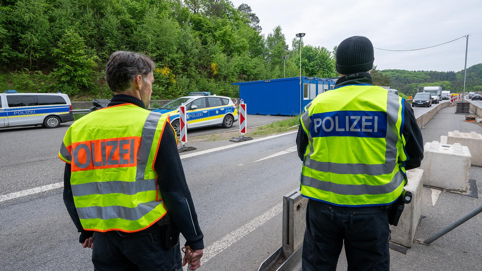 Polizisten beobachten an einer Kontrollstelle auf der A64 Nahe der luxemburgischen Grenze den Verkehr. | dpa