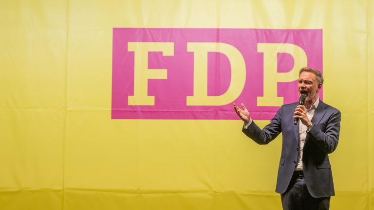 FDP-Chef Lindner steht vor dem Parteilogo 