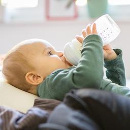 Ein Kleinkind trinkt aus einem Fläschchen.