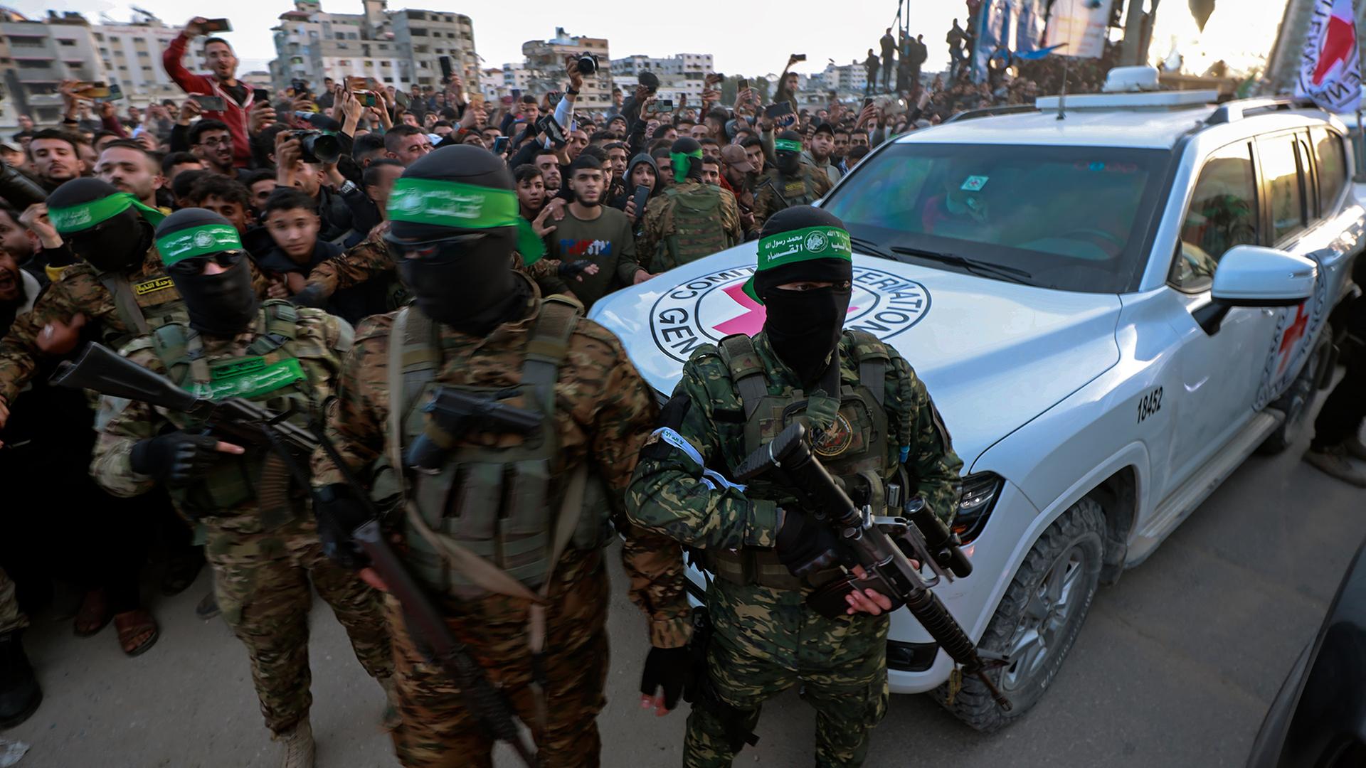 Hamas-Kämpfer eskortieren ein Fahrzeug des Roten Kreuzes in Gaza-Stadt.