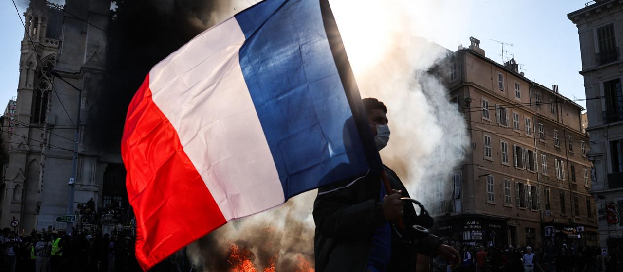 Ein Demonstrant geht mit einer französischen Nationalflaggge durch Marseille, Frankreich.