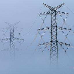 Strommasten ragen am Morgen aus dem Nebel in Oberschwaben.