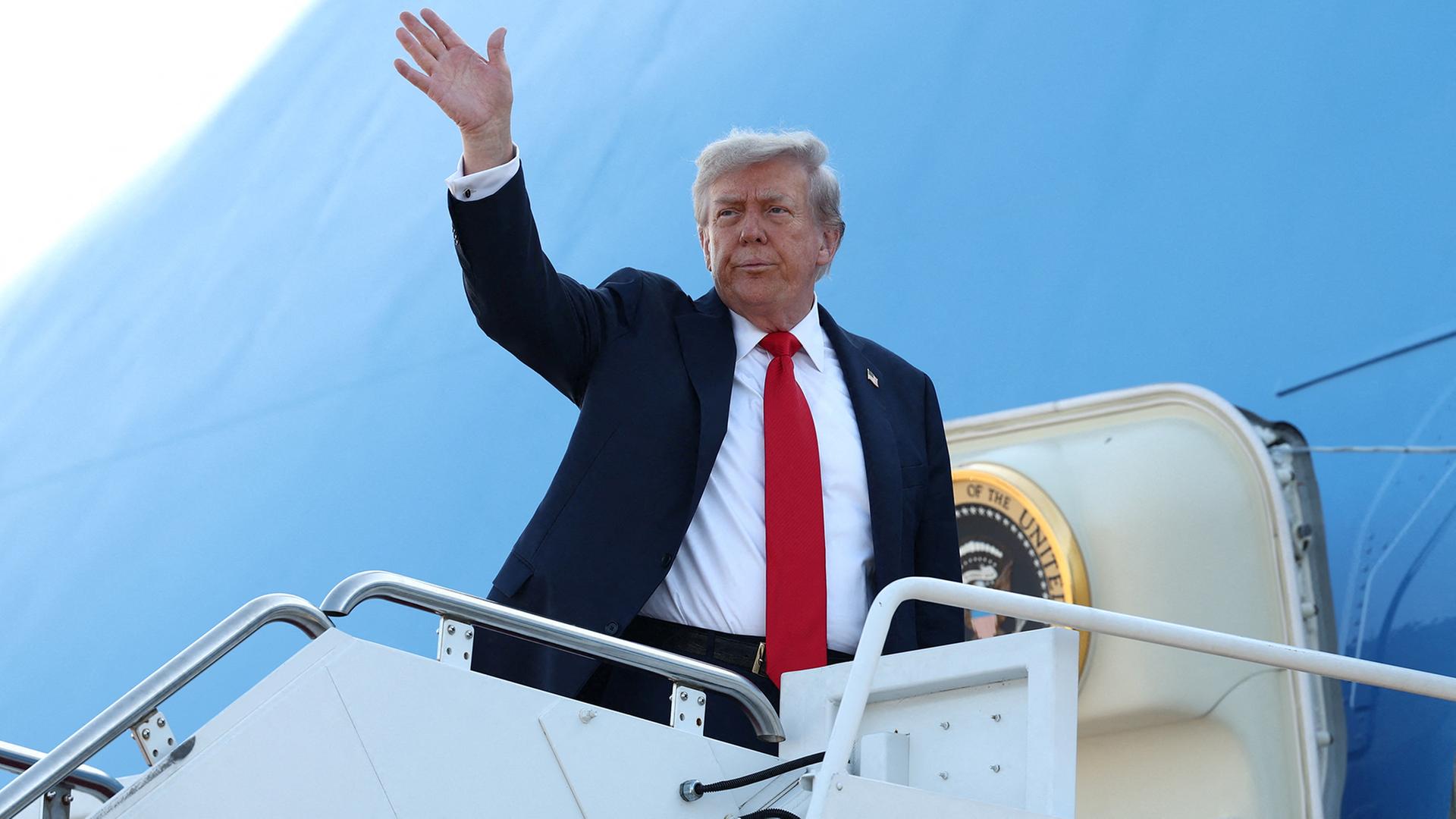 Donald Trump winkt beim Einstieg in die Air Force One. | REUTERS