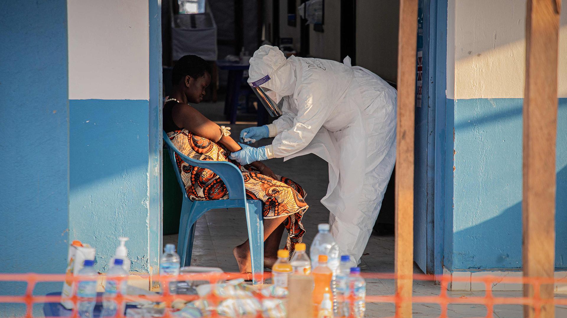 Eine Ebola-Patientin wird von medizinischen Personal behandelt. | AFP