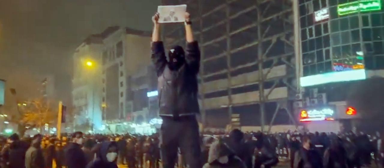 Ein maskierter Demonstrant hält während einer Demonstration in Teheran ein Bild des iranischen Kronprinzen Reza Pahlavi hoch.