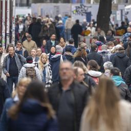 Passanten laufen durch eine Fußgängerzone in München.
