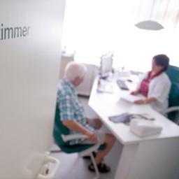 In der Tür einer Hausarztpraxis ist der Schriftzug "Sprechzimmer" zu sehen.