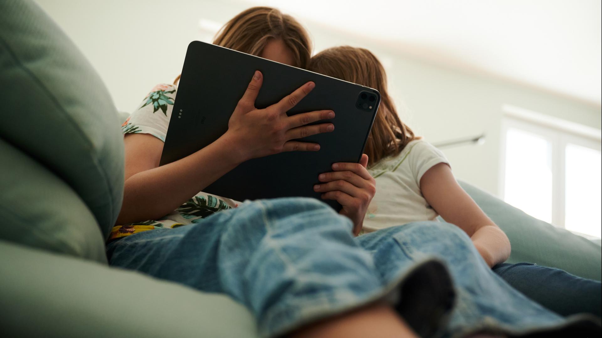 Zwei Kinder schauen auf ein Tablet. | dpa