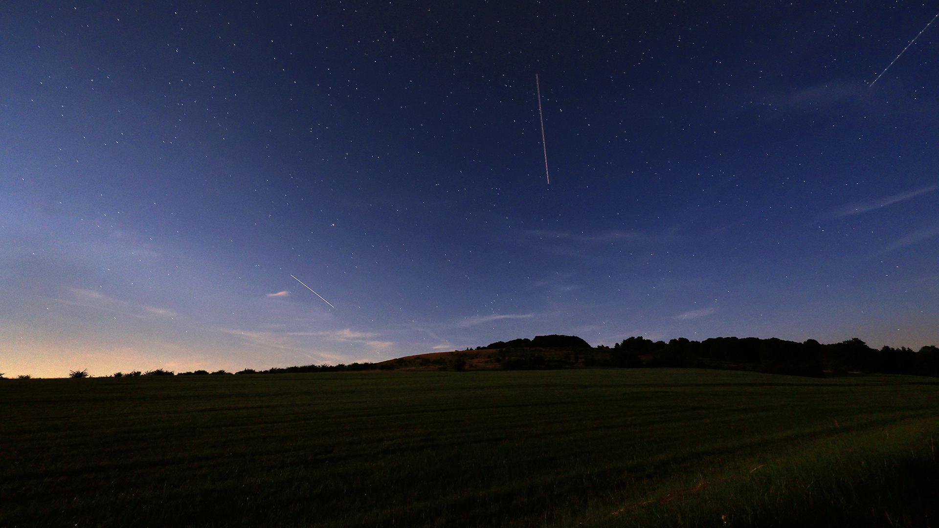 Unter einem Sternenhimmel liegt die Landschaft nahe des Kreuzbergs in Bischofsheim, Bayern.  | dpa