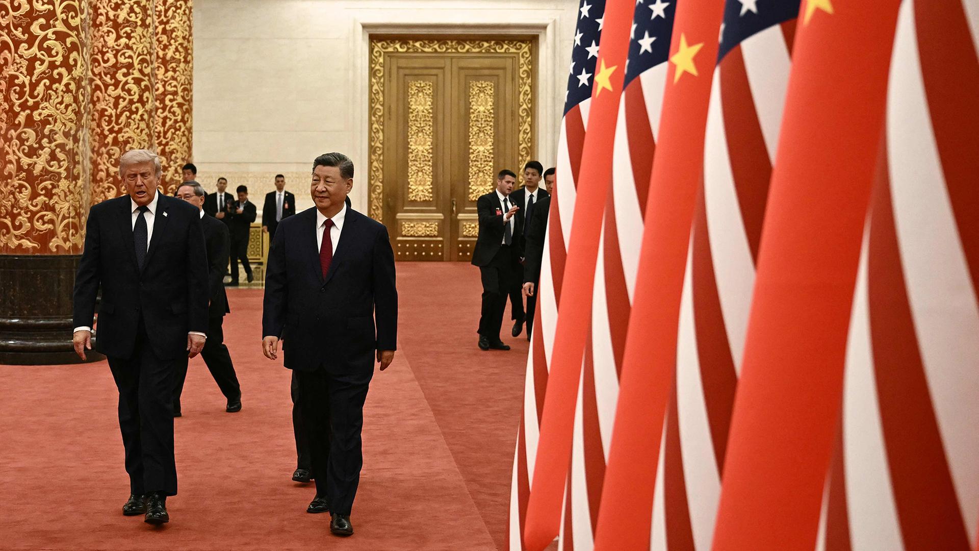  Donald Trump und Xi Jinping (rechts) laufen an Landesfahnen der USA und China vorbei zu einem Staatsbankett in Peking. | AFP