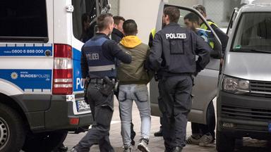  Polizisten bringen einen jungen Mann zur Abschiebung zum Flughafen.