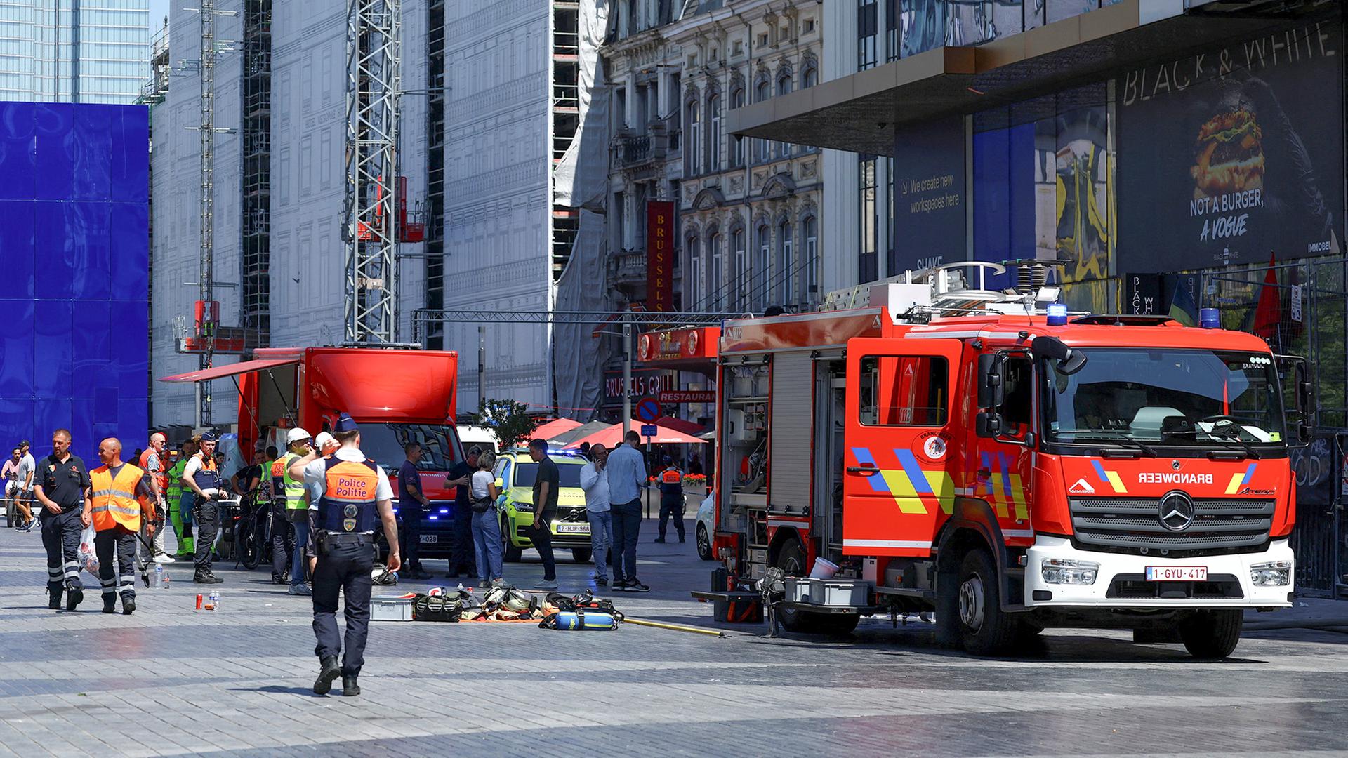 Einsatzkräfte und Feuerwehrfahrzeuge stehen am Oxy-Gebäude in Brüssel, Belgien. | REUTERS