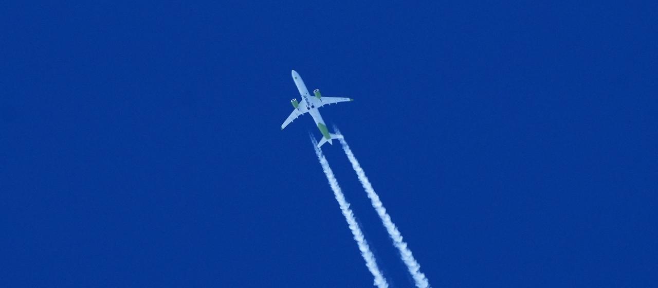 Ein Flugzeug der staatlichen lettischen Fluggesellschaft Air Baltic zieht am Himmel einen Kondensstreifen hinter sich her