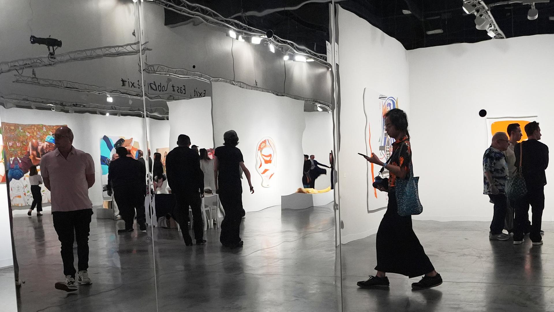 Menschen laufen durch eine Ausstellung auf der Art Basel Miami Beach. | AP
