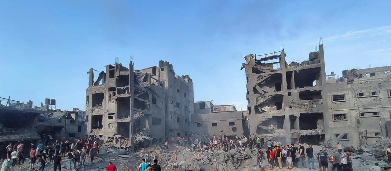 Menschen vor zerstörten Häusern