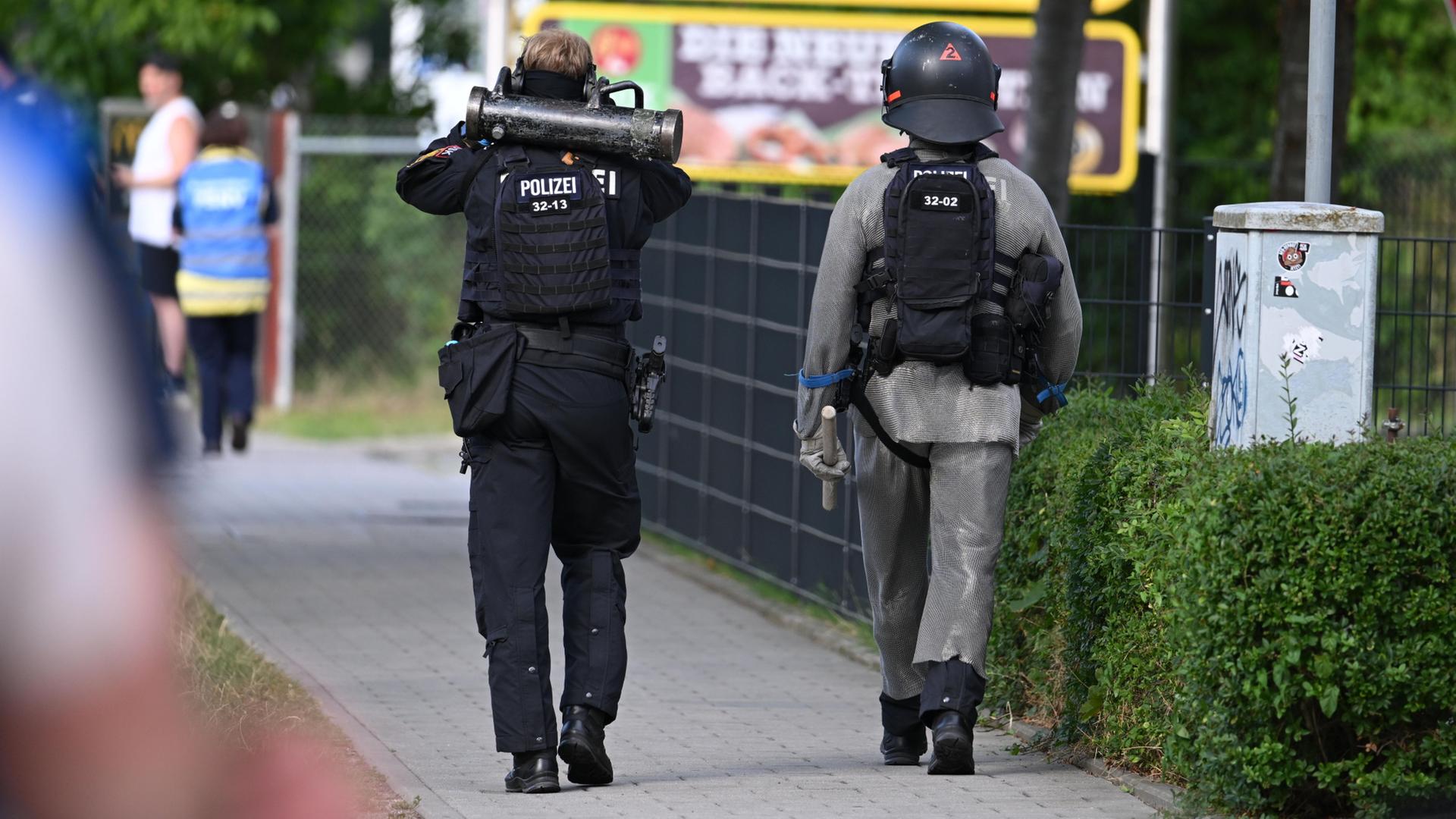 Zwei Polizisten gehen einen Fußweg entlang | Armin Weigel/dpa