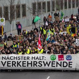 Demonstrierende halten in Berlin Banner, Schilder und Fahnen hoch und protestieren für eine Verkehrswende.