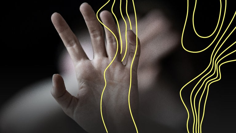 Eine Frau hält ihre Hände schützend vor das Gesicht.