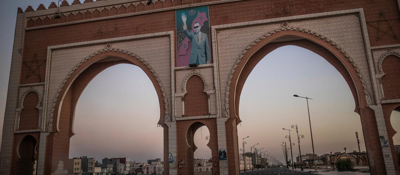 Ein Torbogen in Dakhla mit dem Bild von König Mohammed VI.