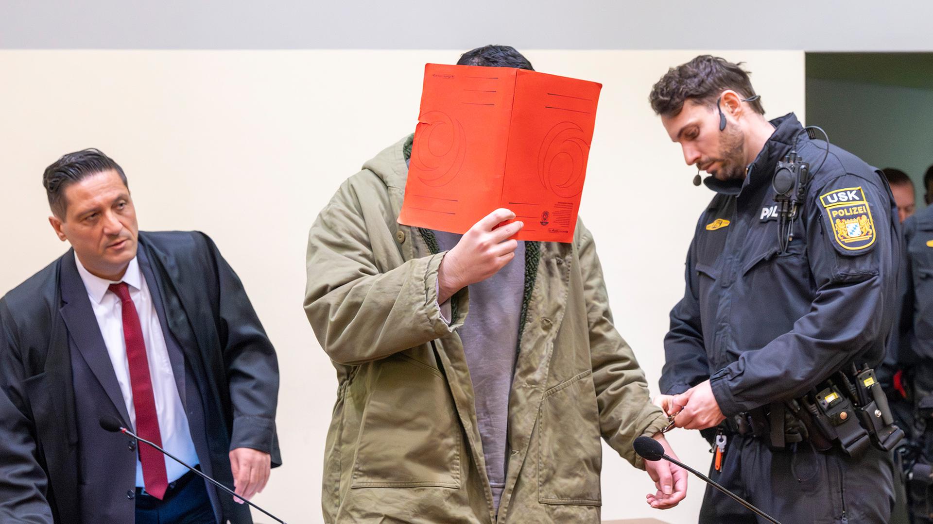 Ein Angeklagter wird in einen Prozesssaal geführt. | dpa