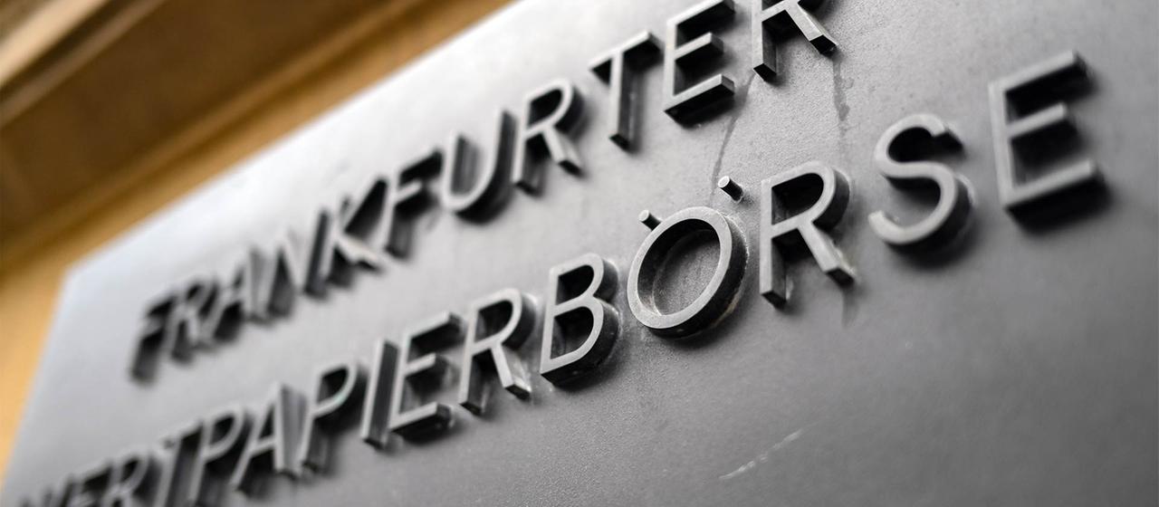 Eine Metallplatte mit der Aufschrift "Frankfurter Wertpapierbörse" an der Fassade vor der Frankfurter Börse.