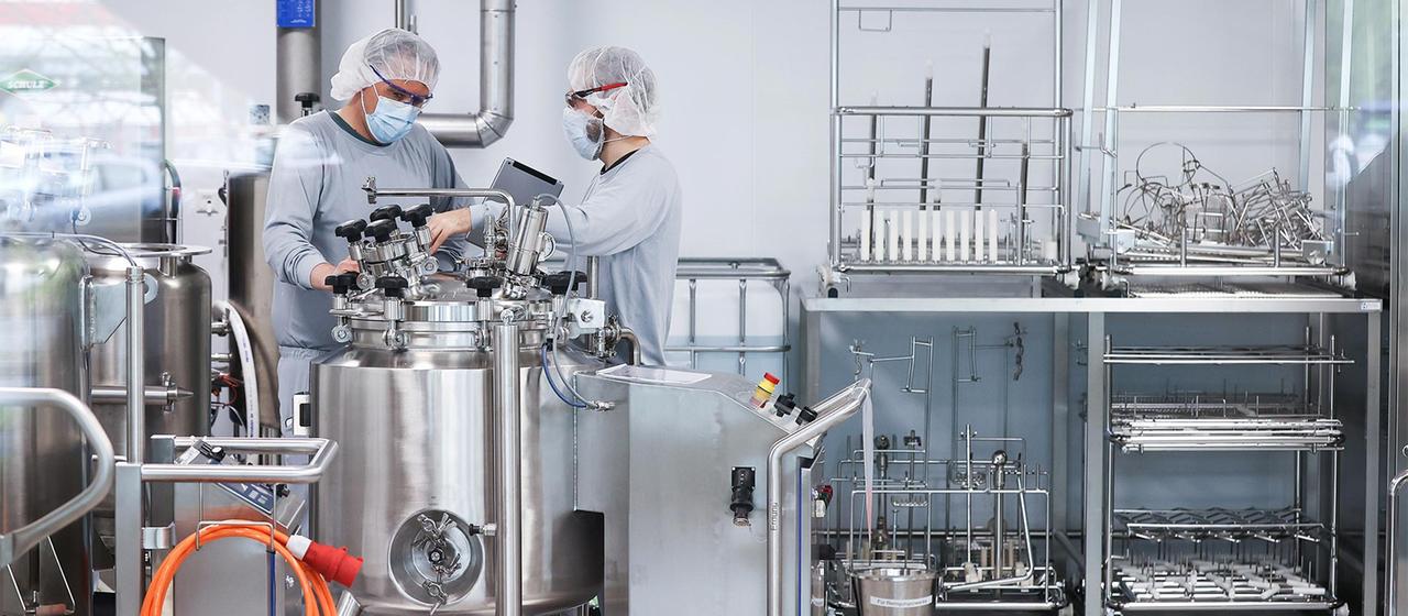 Mitarbeiter in Reinraumkleidung in der Produktion von Biontech/Pfizer, Reinbek.