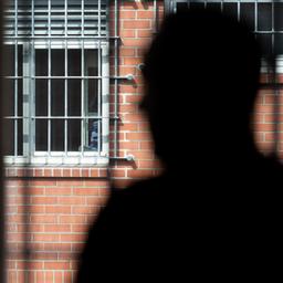 Ein Insasse blick aus einem vergitterten Fenster  aus einer Unterbringungseinrichtung für Ausreisepflichtige in Büren